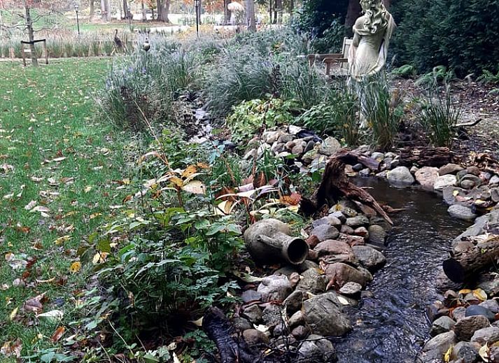 Charming facade of Holiday Home in De Bult, Overijssel, with flowering hydrangeas and an inviting entrance.