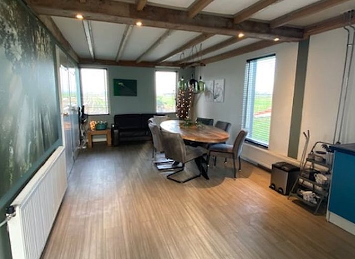 Geraeumiges Esszimmer im Ferienhaus in Wanneperveen, Nordwest Overijssel, mit Holzbalken und viel Licht.