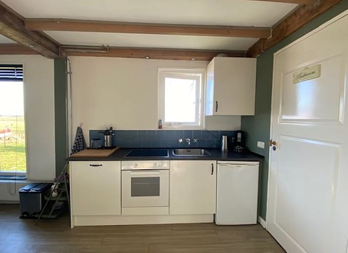 Geraeumiges Esszimmer im Ferienhaus in Wanneperveen, Nordwest Overijssel, mit Holzbalken und viel Licht.