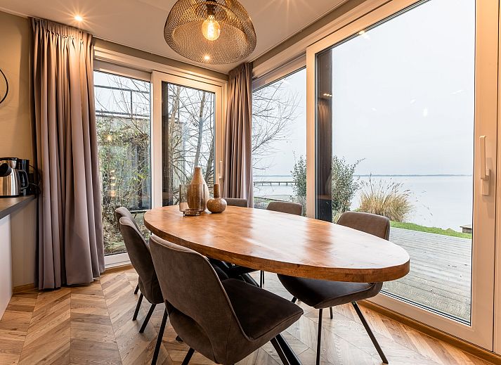 Uitzicht op het meer vanuit de Vrijstaande woning in Wanneperveen, een vakantiehuis in Noordwest Overijssel, omgeven door serene natuur.