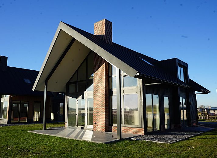 Gezellige woonkamer van de Vrijstaande woning in Kampen, Overijssel, met moderne inrichting en uitzicht op de groene tuin.