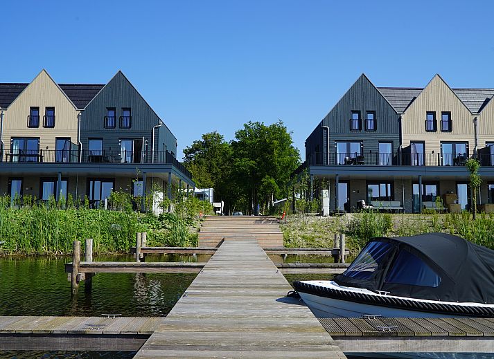 Bright living room in Chalet in Kampen, Overijssel, with comfortable seating area and views of nature.