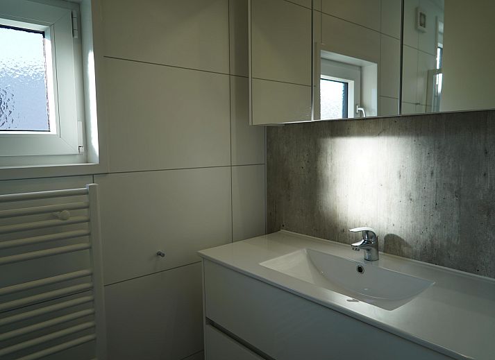 Stijlvolle woonkamer in de Vrijstaande woning in Kampen, Overijssel, met grote ramen en modern interieur.