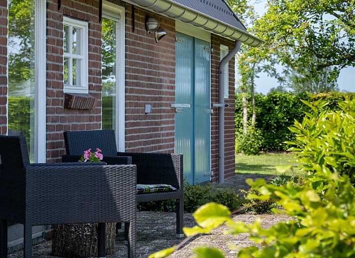 Eetruimte in OV701 vakantiehuis Scheerwolde, Overijssel met kleurrijke servies en jam op tafel.