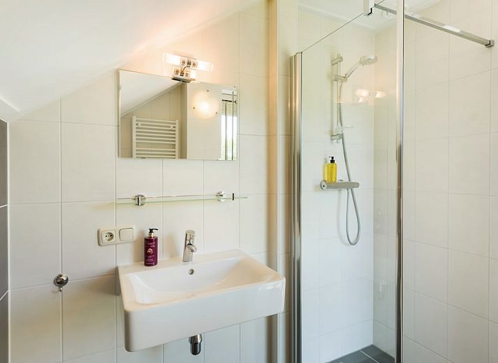 Moderne Kueche und Wohnzimmer im Ferienhaus Waterjuffer 8 in Paasloo, Overijssel, mit Blick auf die gruene Umgebung.