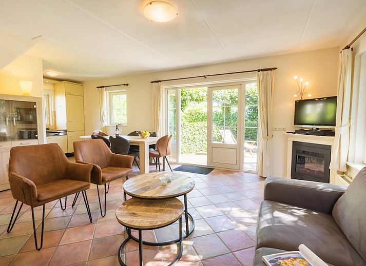 Gezellige woonkamer in vakantiehuis Tjasker 6, Paasloo, met comfortabele zithoek en uitzicht op groene tuin in Noordwest Overijssel.