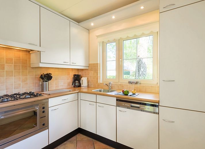 Gezellige woonkamer in vakantiehuis Tjasker 6, Paasloo, met comfortabele zithoek en uitzicht op groene tuin in Noordwest Overijssel.