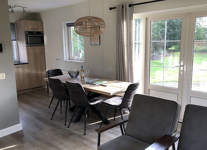 Helles Wohnzimmer des Ferienhauses Tjasker Comfort 6 in Paasloo, Nordwest Overijssel, mit bequemen Sitzgelegenheiten und Blick ins Gruene.