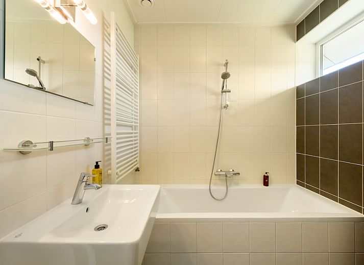 Geraeumiges Wohnzimmer im Ferienhaus Grote Waterjuffer 16, Paasloo, Overijssel, mit moderner Kueche und gemuetlicher Sitzecke.