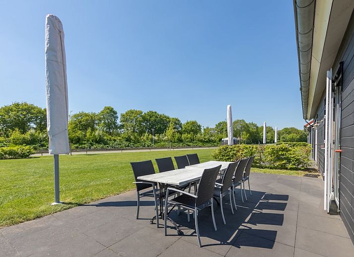 Gemuetliches Wohnzimmer im Ferienhaus Grote Waterjuffer 16, Paasloo, Overijssel mit komfortablen Moebeln und Blick auf die Natur.