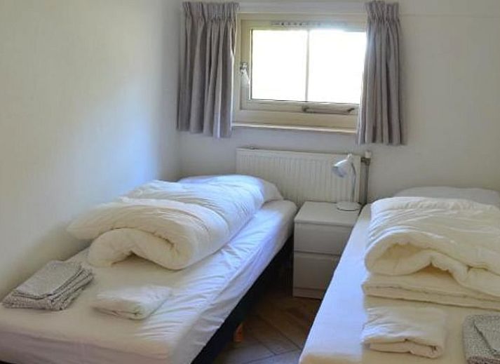 Helles Interieur eines Ferienhauses in IJhorst mit offener Tuer zum Schlafzimmer.
