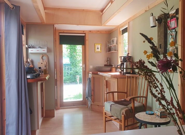 Rustikaler Picknicktisch am Ferienhaus in IJhorst, Overijssel, mit bunten Blumen.