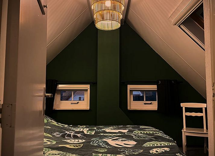 Gemuetliches Wohnzimmer des Ferienhauses in IJhorst mit Kaminofen und bequemen Sitzgelegenheiten, ideal zum Entspannen.