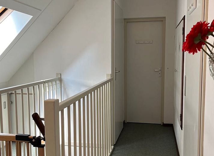 Stilvolle Chaiselongue im Ferienhaus in IJhorst, umgeben von Buechern und gruener Aussicht in Overijssel.