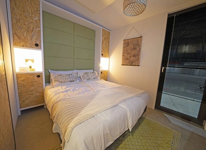 Modernes Wohnzimmer in einem freistehenden Haus in IJhorst, Overijssel, mit grnen Akzenten und Blick auf den Garten.