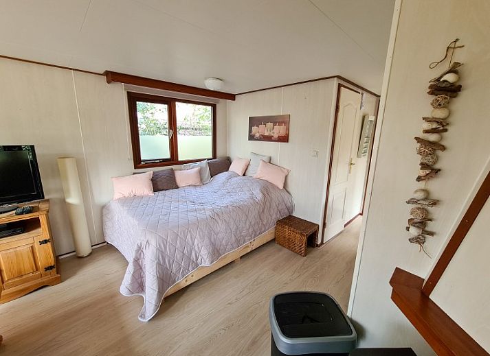 Sfeervolle toegangspoort naar Chalet Boslust in IJhorst, omgeven door bloeiende flora in Overijssel.