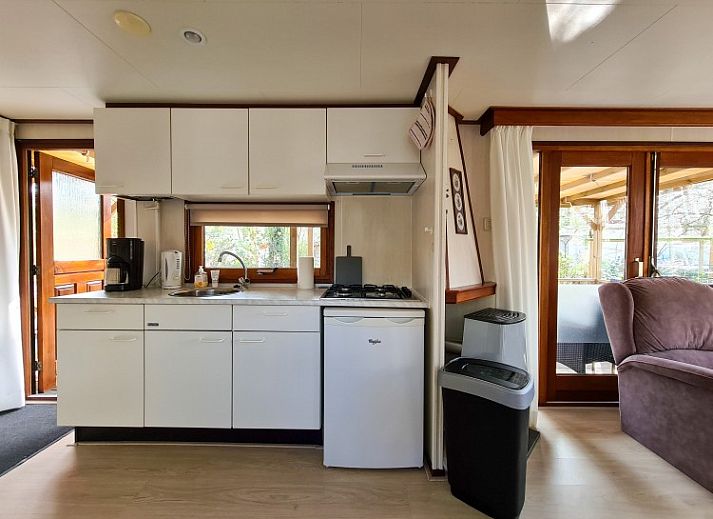 Sfeervolle toegangspoort naar Chalet Boslust in IJhorst, omgeven door bloeiende flora in Overijssel.