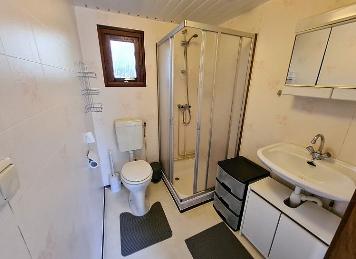 Sfeervolle toegangspoort naar Chalet Boslust in IJhorst, omgeven door bloeiende flora in Overijssel.