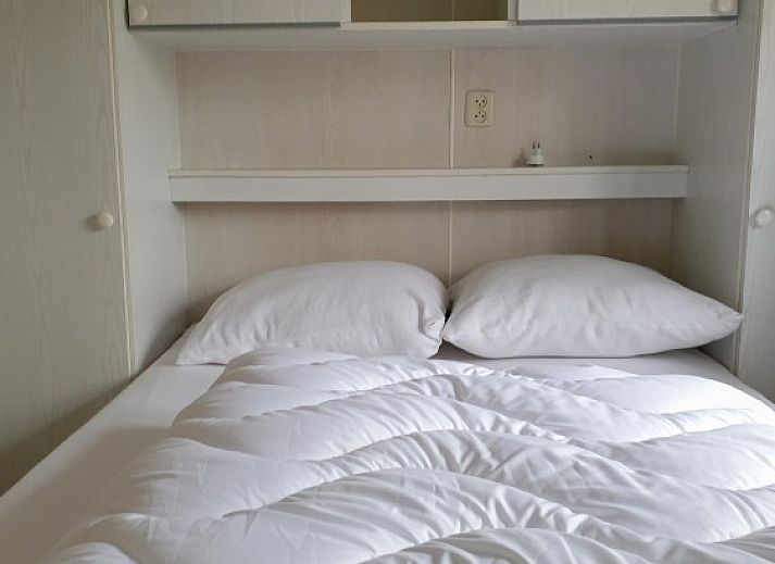 Sfeervolle toegangspoort naar Chalet Boslust in IJhorst, omgeven door bloeiende flora in Overijssel.