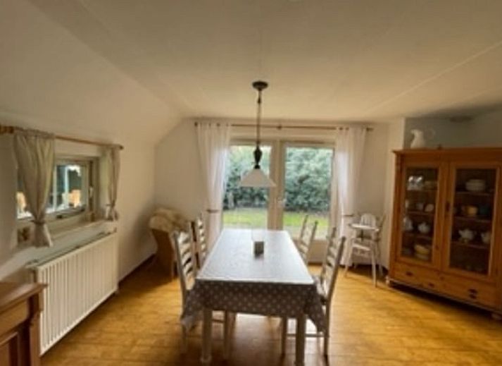 Dining room of Holiday home in IJhorst overlooking green garden, ideal for cozy meals.