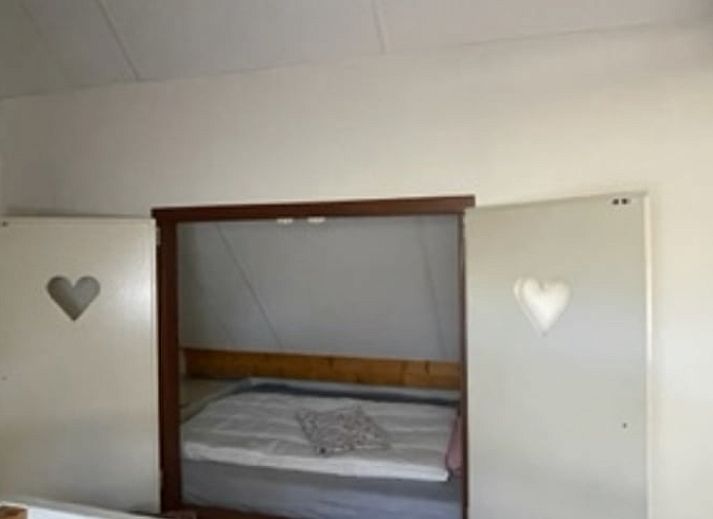 Dining room of Holiday home in IJhorst overlooking green garden, ideal for cozy meals.