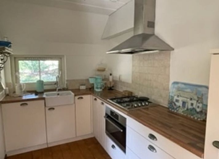 Dining room of Holiday home in IJhorst overlooking green garden, ideal for cozy meals.