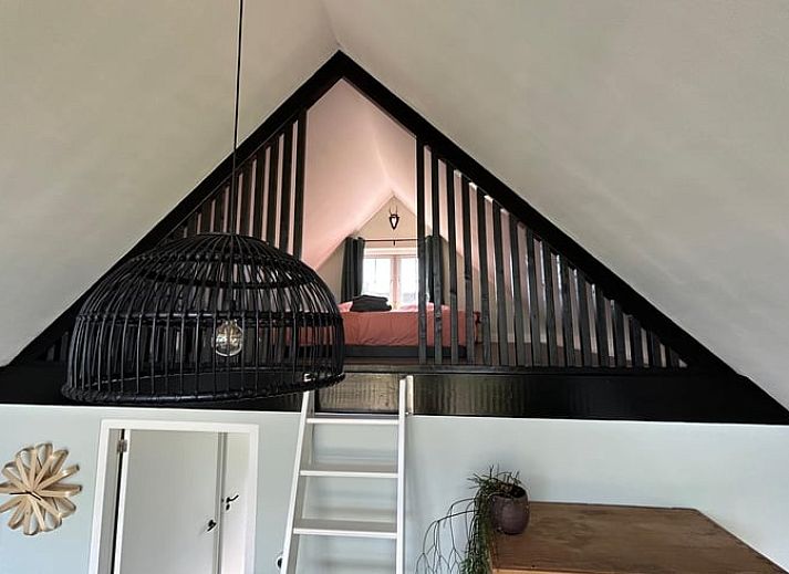 Lichte woonkamer van Vakantiehuis in Kalenberg, Overijssel, met grote ramen en uitzicht op de groene omgeving.