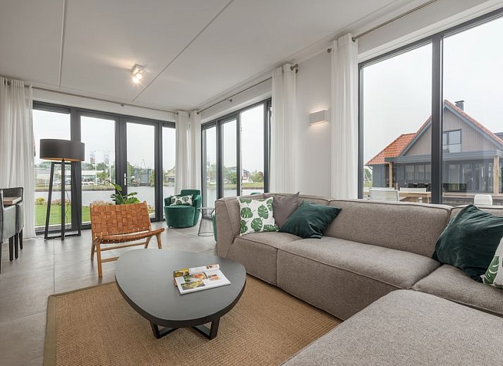 Lichte woonkamer in Watervilla 8, een vakantiehuis in Ossenzijl, Noordwest Overijssel, met uitzicht op het water en moderne inrichting.