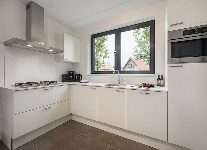 Lichte woonkamer in Watervilla 8, een vakantiehuis in Ossenzijl, Noordwest Overijssel, met uitzicht op het water en moderne inrichting.