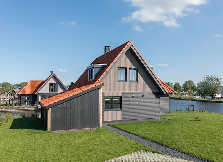 Gezellige woonkamer in Watervilla 8, een vakantiehuis in Ossenzijl, Noordwest Overijssel, met moderne inrichting en sfeervolle haard.