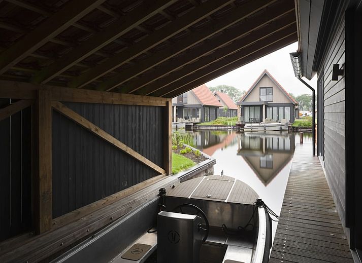Gezellige woonkamer in Watervilla 8, een vakantiehuis in Ossenzijl, Noordwest Overijssel, met moderne inrichting en sfeervolle haard.