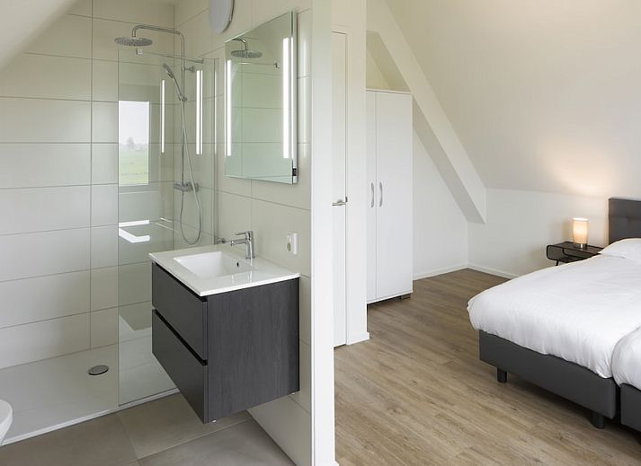 Moderne woonkamer van Watervilla 6B in Ossenzijl, Overijssel met uitzicht op de natuur door grote ramen.