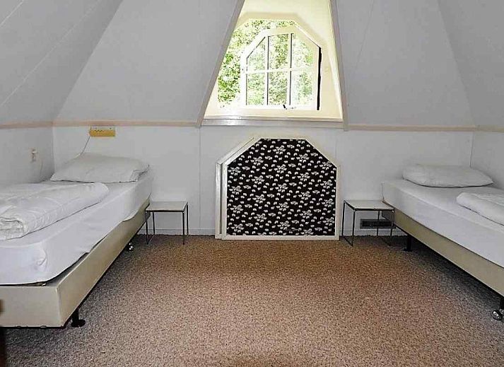 Gezellige woonkamer van OV400 vakantiehuis in Ossenzijl met houtkachel en uitzicht op de natuur.