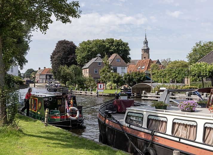 Lichtdurchfluteter Innenraum des Ferienhauses OV735 in Tuk, Overijssel, mit Blick auf den gruenen Garten und moderne Pendelleuchten.