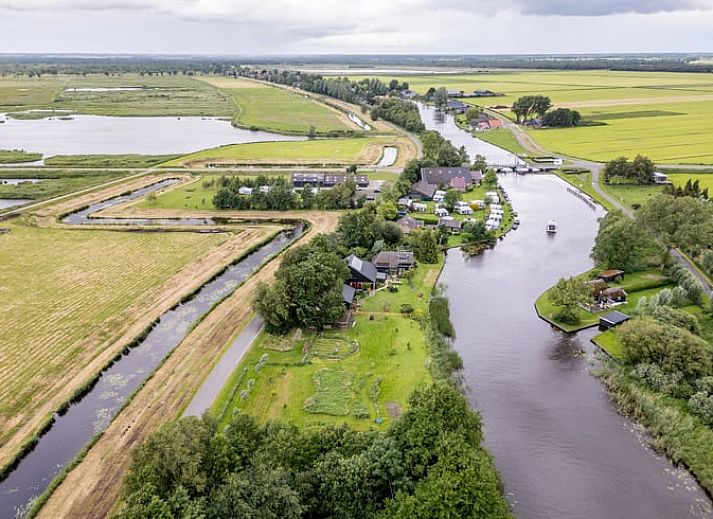 Sfeervolle slaapkamer in Vakantiehuisje in Wetering, Overijssel. Comfortabel bed onder een dakraam.