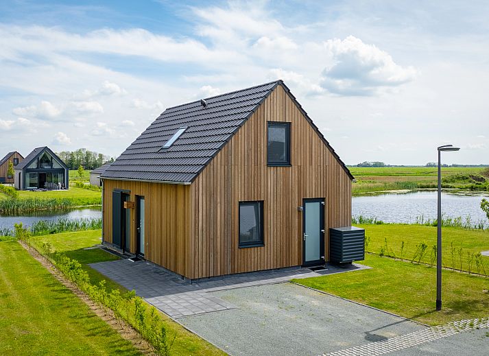Moderne Sitzecke im 4-Bett-Haus 4CE3, Blokzijl, mit Ledersofa und dekorativen Elementen in Overijssel.