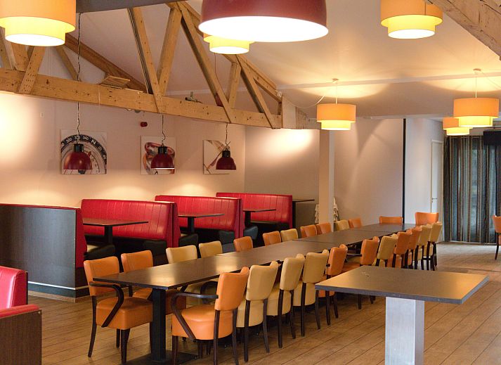 Stijlvolle lounge met rode banken in vakantiehuis OV670, Blokzijl, Overijssel, ideaal voor ontspanning.