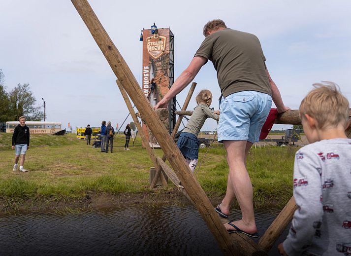 Houten uitkijktoren bij vakantiehuis OV670, Blokzijl, Overijssel, omringd door weelderige natuur.