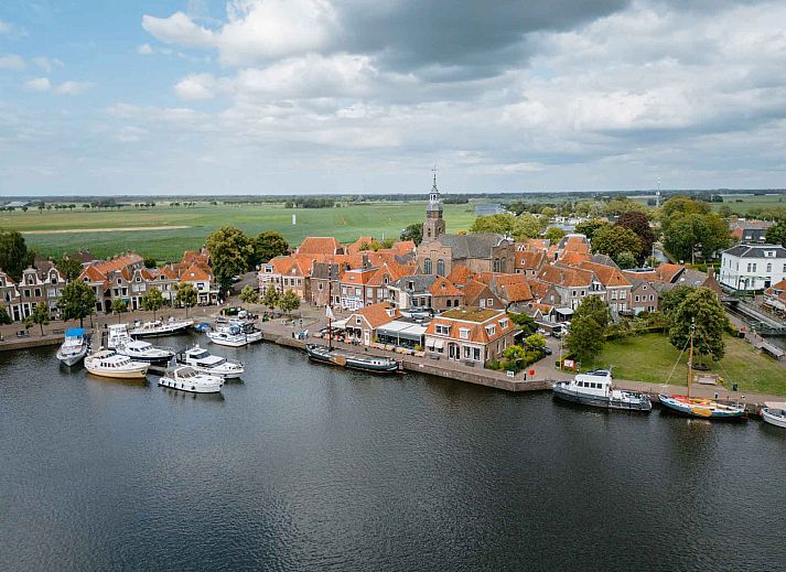 Cozy living room of OV684 vacation home in Blokzijl, with flowers and comfortable sofa, Northwest Overijssel.