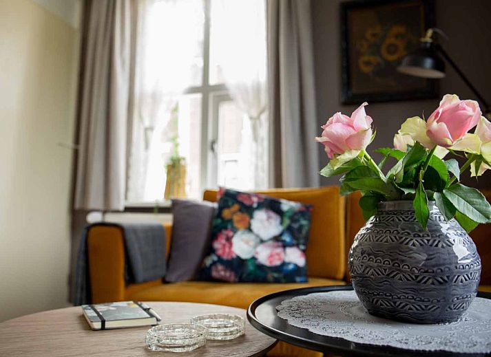 Cozy living room of OV684 vacation home in Blokzijl, with flowers and comfortable sofa, Northwest Overijssel.