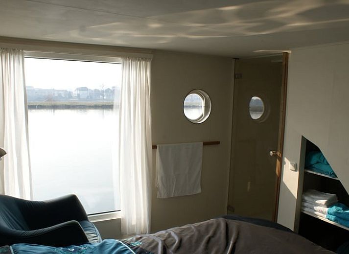 Ruime woonkamer met houtkachel in Vakantiehuis in IJsselmuiden, Noordwest Overijssel.