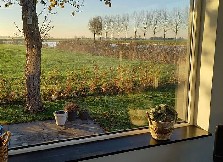 Green garden overlooking the water at Holiday home in IJsselmuiden, ideal for relaxation.