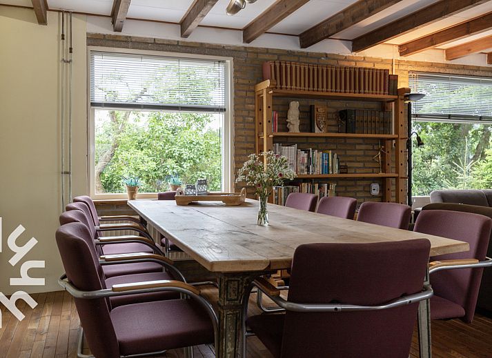 Gemuetliches Wohnzimmer von OV533 in Eesveen, mit bequemen Sesseln und einem Holzofen.