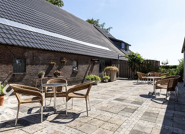 Gemuetliches Wohnzimmer von OV533 in Eesveen, mit bequemen Sesseln und einem Holzofen.