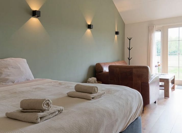 Blick vom Ferienhaus in Eesveen, Overijssel, mit offenen Tueren zu gruenen Feldern.