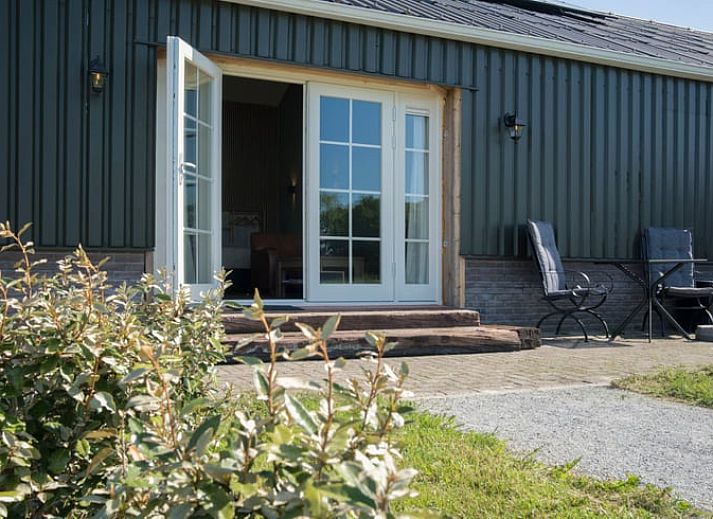 Blick vom Ferienhaus in Eesveen, Overijssel, mit offenen Tueren zu gruenen Feldern.