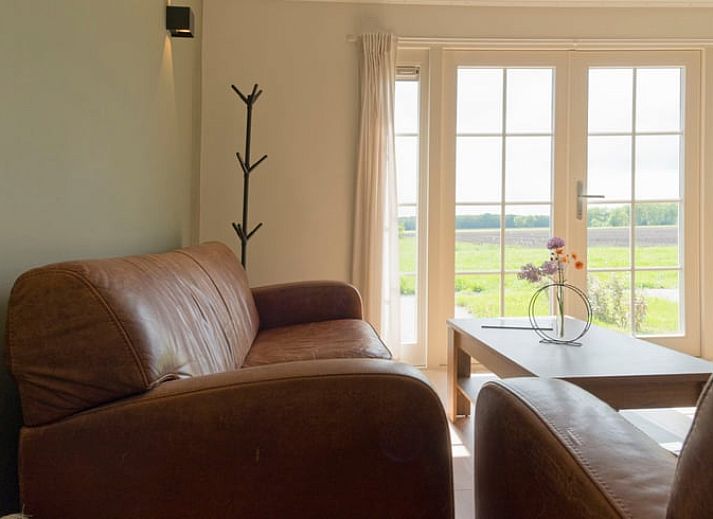 Blick vom Ferienhaus in Eesveen, Overijssel, mit offenen Tueren zu gruenen Feldern.