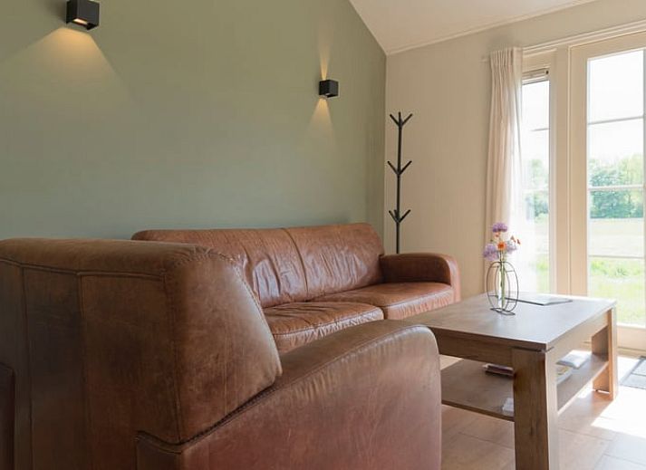 Terrasse des Ferienhauses in Eesveen, Overijssel, mit Terrassentueren und Sitzgelegenheiten.