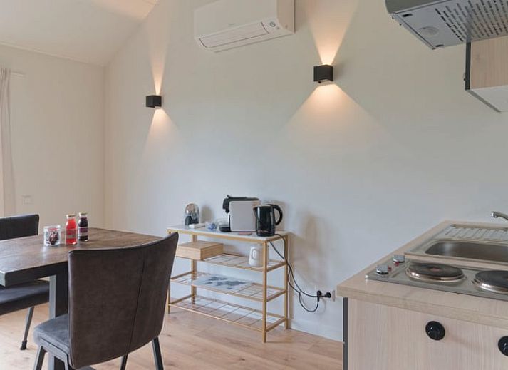 Terrasse des Ferienhauses in Eesveen, Overijssel, mit Terrassentueren und Sitzgelegenheiten.