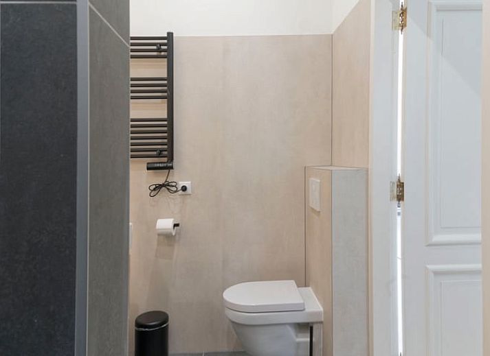 Terrasse des Ferienhauses in Eesveen, Overijssel, mit Terrassentueren und Sitzgelegenheiten.